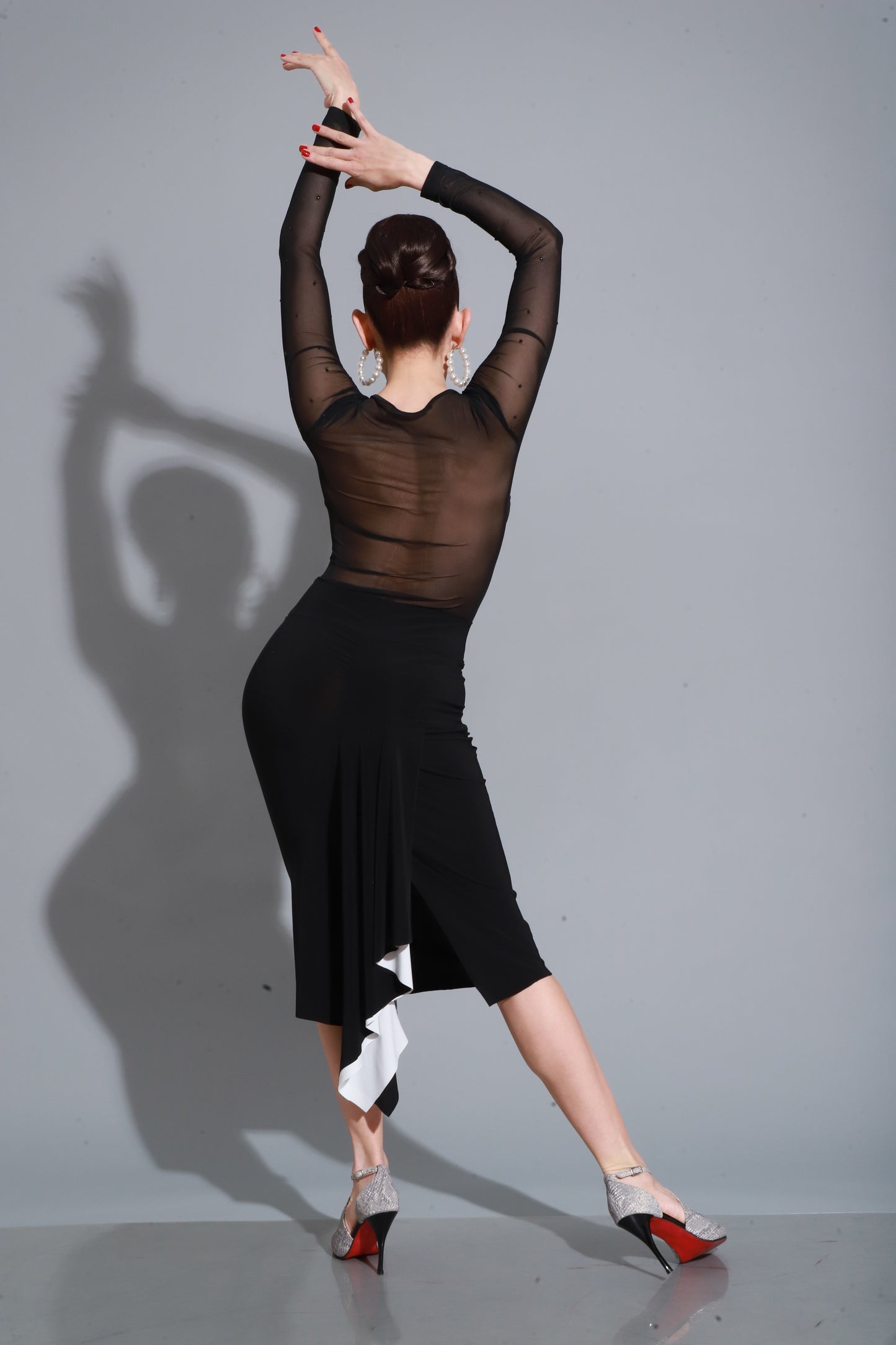 Pure lines in black crepe with sweetheart neckline and sheer sleeves, finished with a side slit for an elegant, sensual look.