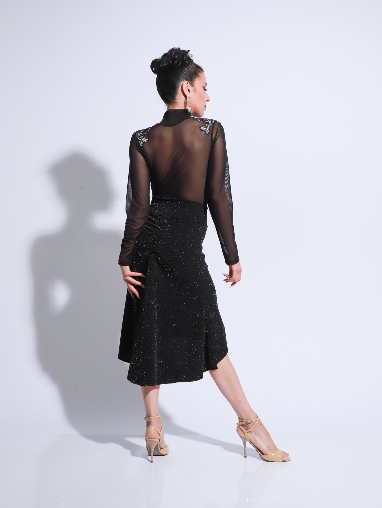 Pollera de tango en color negro con cintura entallada, leve amplitud y silueta de largo midi.