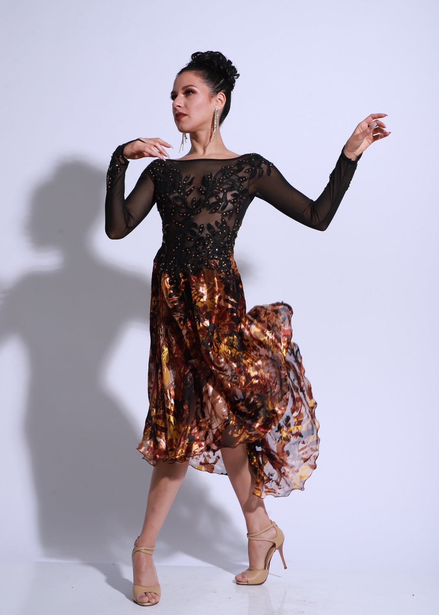Dress featuring a black embroidered lace bodice with sheer sleeves. The skirt is made of printed satin in warm earthy tones, with a fluid movement and asymmetrical drape. An elegant and dynamic design, perfect for stage and showcase performances.