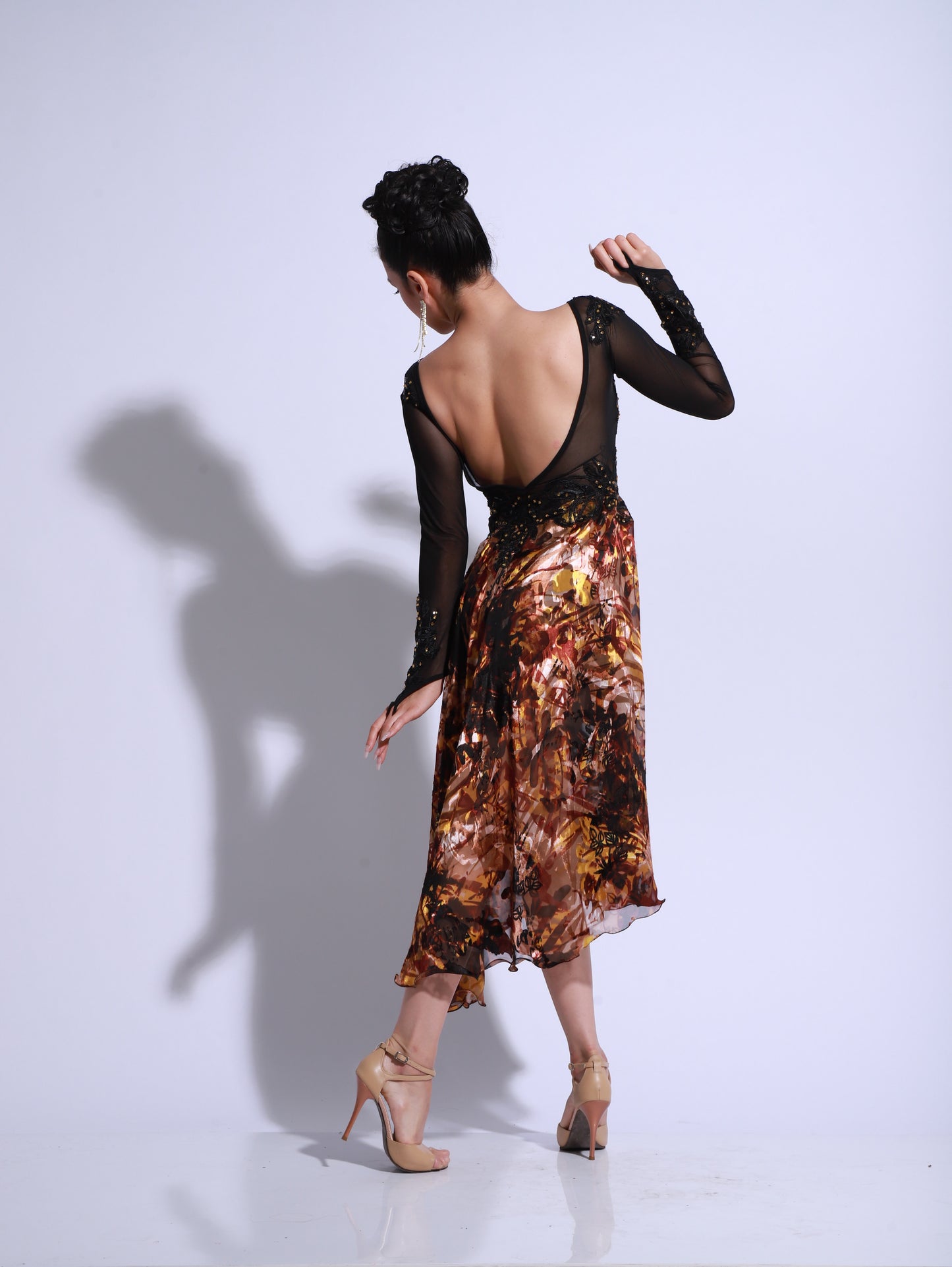 Dress featuring a black embroidered lace bodice with sheer sleeves. The skirt is made of printed satin in warm earthy tones, with a fluid movement and asymmetrical drape. An elegant and dynamic design, perfect for stage and showcase performances.
