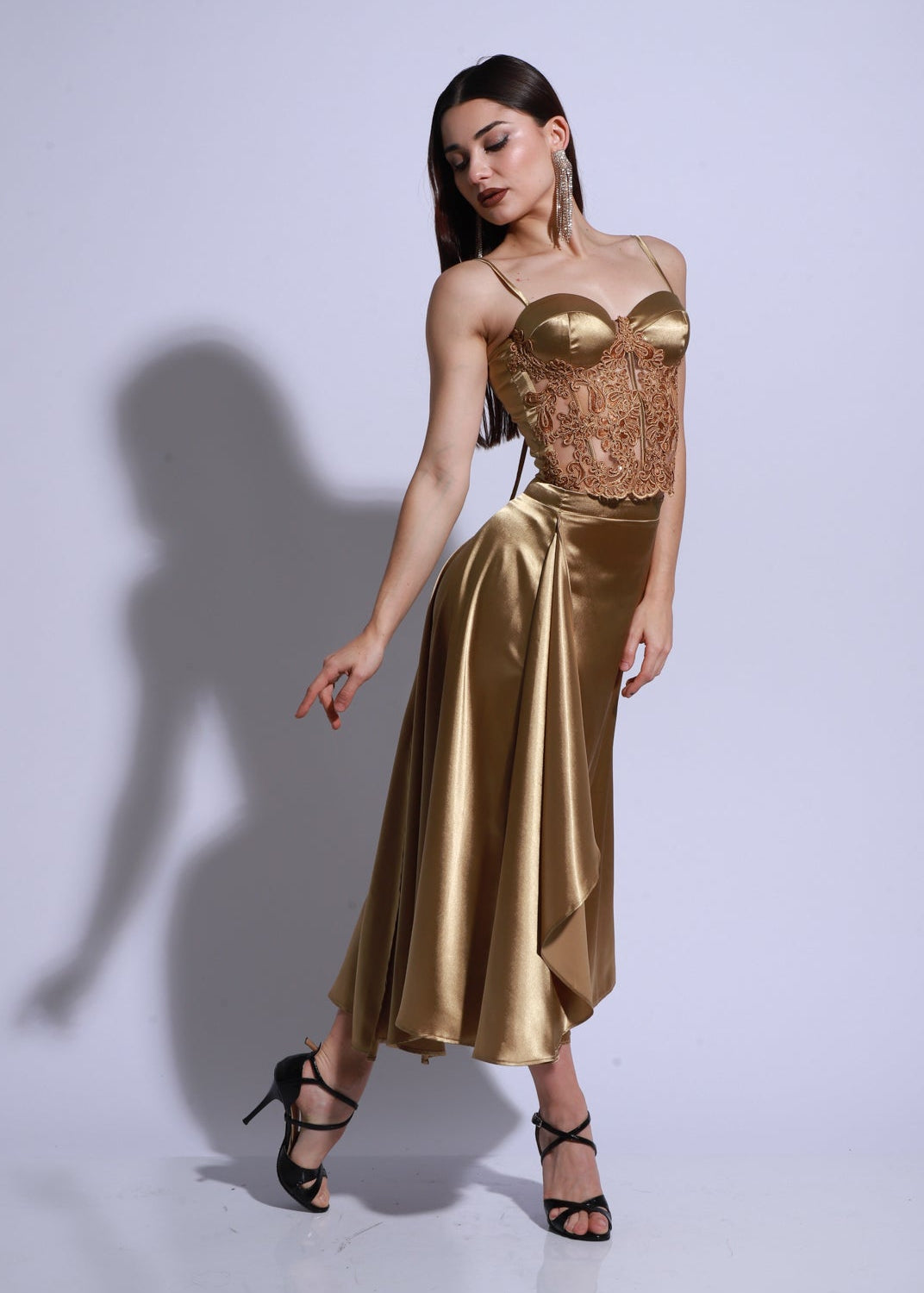 Vestido de tango confeccionado sobre body con corset bordado a mano y falda de satén con caída fluida.
Su diseño realza la figura con elegancia y un brillo dorado que ilumina el movimiento.
Cada vestido es una pieza única, especialmente pensada y creada para ti.