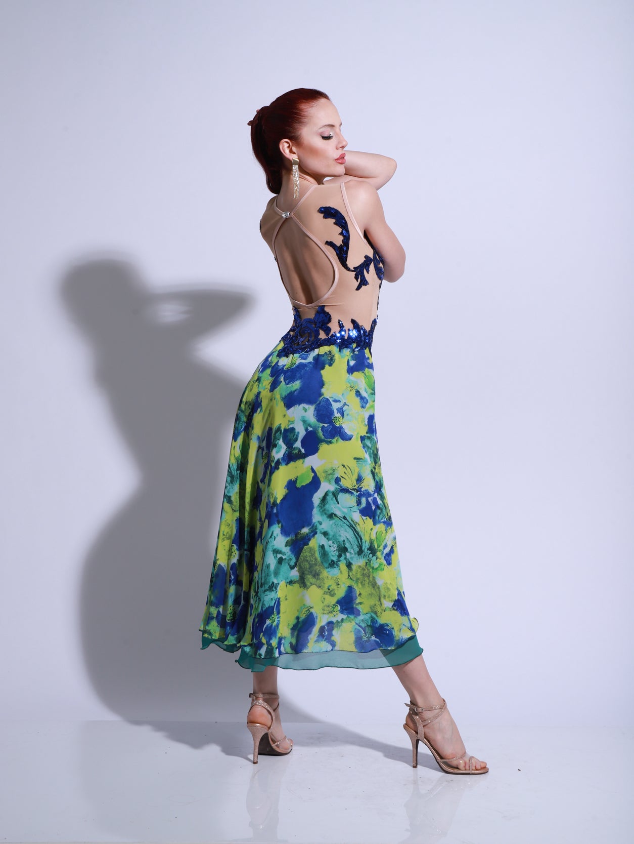 Vestido de escenario de tango con cuerpo de encaje azul marino y falda multicolor floral, con tajo y caída suave.