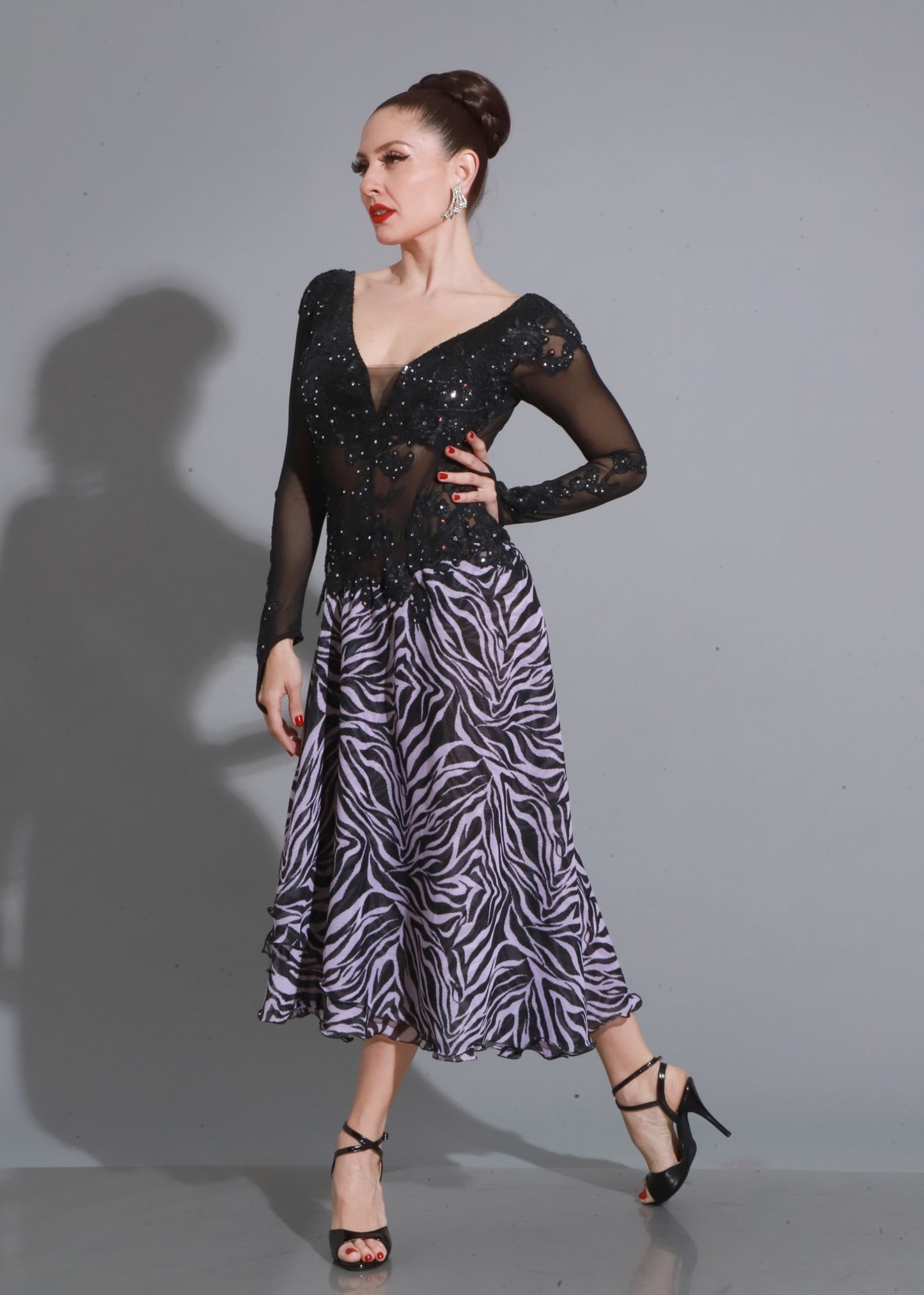 Diseño en tul y encaje negro con bordados brillantes y abertura lateral, sofisticado y sensual para la pista.