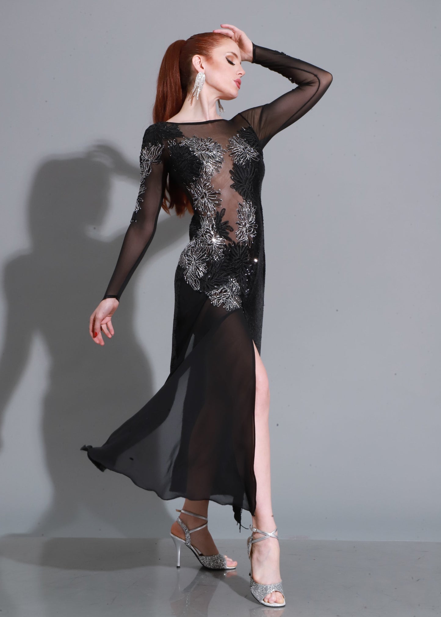 Encaje negro con bordados y transparencias, falda con abertura y caída fluida: un diseño audaz y sofisticado.