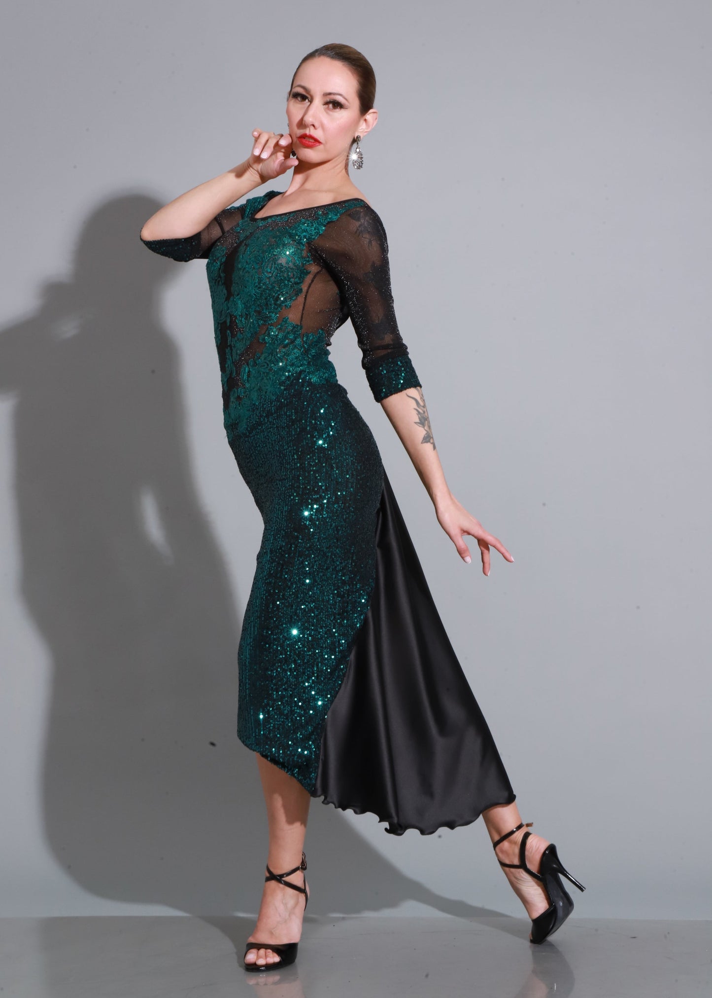 Brillo en lentejuelas verde esmeralda con mangas de tul negro y falda con abertura, un diseño elegante y magnético.