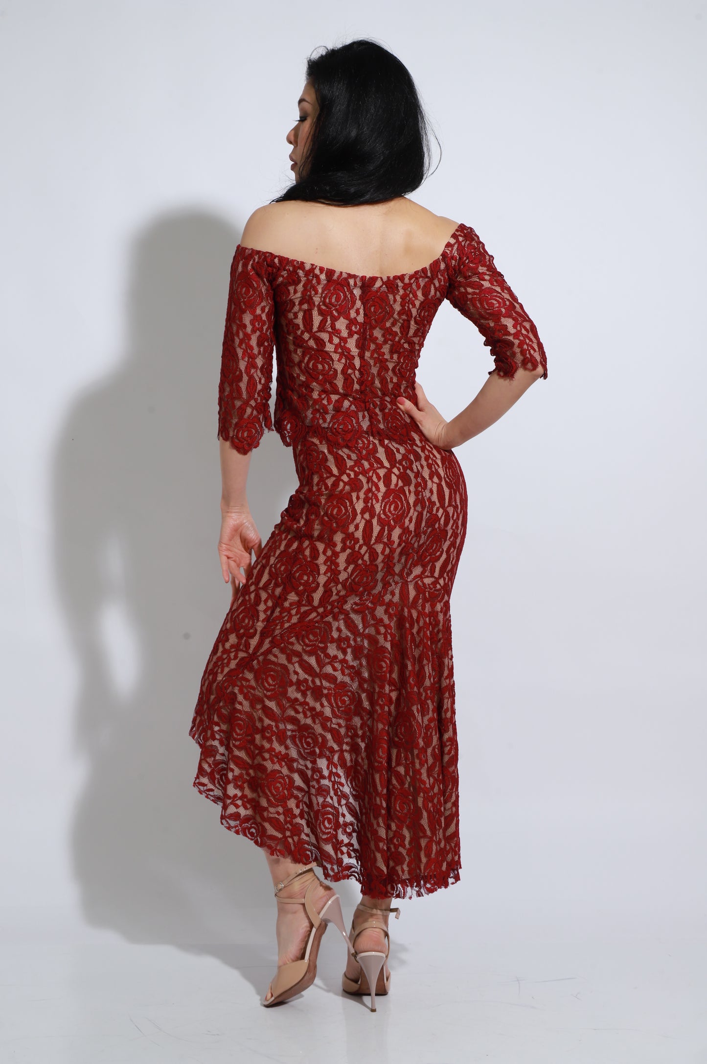 Elegant red lace dress featuring an off-the-shoulder neckline and three-quarter sleeves. The asymmetric skirt adds movement and a sophisticated flow, making it perfect for special events, tango, or any occasion that calls for a refined and feminine look. The soft lace and fitted silhouette beautifully enhance the figure with a romantic, modern touch.